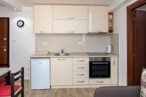 a small kitchen with white cabinets and a sink at Dea Central Apartment in Risan