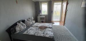 a large bed in a bedroom with a window at Relax Apartman in Siófok