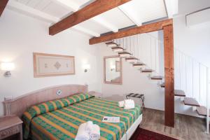 a bedroom with a bed and a staircase at Locanda degli Artisti in Tortolì