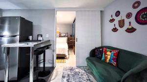 a living room with a green couch and a kitchen at Casa Dodo Guatapé in Guatapé