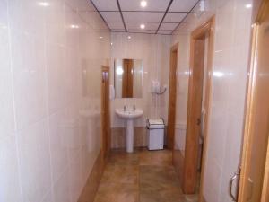 a white bathroom with a sink and a mirror at Hostal Athlanta in Villalpando