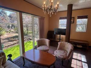 a living room with a table and chairs and a television at Rose Garden Esta in Kashiwa