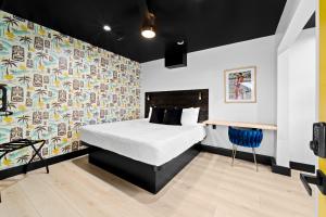 - une chambre avec un lit et un mur coloré dans l'établissement Balboa Park Hotel in Downtown Little Italy, à San Diego
