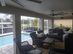 a living room with chairs and a swimming pool at The Cape - Four Bedroom in Cape Coral