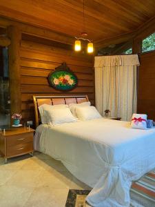 une chambre avec un grand lit dans une pièce dans l'établissement Pousada Rocamadour, à Marechal Floriano