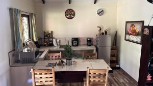 a kitchen with a table and chairs and a refrigerator at Casa Colibrí in Tilarán