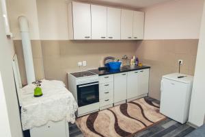 a kitchen with white cabinets and a sink and a refrigerator at Apartman Djole in Foča