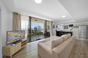 a living room with a couch and a flat screen tv at Ipanema Holiday Resort in Gold Coast