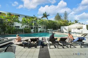 a group of people sitting in chairs by a pool at Ipanema Holiday Resort in Gold Coast