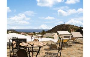 Un patio con mesas y sillas y vista al mar. en Stunning Home In Pantelleria With Wifi, en Pantelleria