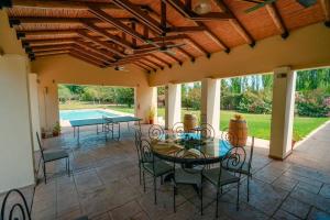 eine Terrasse mit Tisch und Stühlen und einem Pool in der Unterkunft Fabuloso descanso en Mendoza, Pileta, Zona Bodegas in Lunlunta