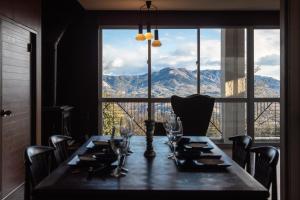 a dining room table with a view of the mountains at Villa TEN ZAN - 岐阜 ヴィラ テンザン - in Mizunami