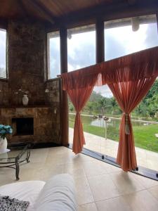 une chambre avec une grande baie vitrée et une cheminée dans l'établissement Pousada Rocamadour, à Marechal Floriano