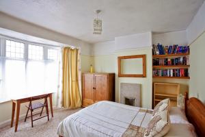 ein Schlafzimmer mit einem Bett, einem Schreibtisch und einem Spiegel in der Unterkunft Holiday Home York in York