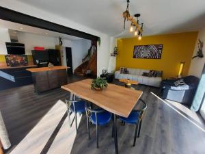 a living room with a wooden table and blue chairs at Maison avec jardin près de Luchon in Cazaux-Layrisse +19 photos