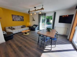 a living room with a table and a couch at Maison avec jardin près de Luchon in Cazaux-Layrisse