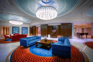 a large living room with blue couches and a table at Resorts World Sentosa - Crockfords Tower in Singapore