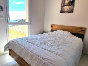 sypialnia z białym łóżkiem i oknem w obiekcie T4 climatisé à 2 min de la plage, parking privé, terrasse, pour 6 pers - Banyuls-sur-Mer - FR-1-309-359 w mieście Banyuls-sur-Mer
