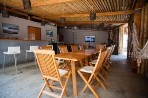 a dining room with a wooden table and chairs at El Hueco Villas in Lobitos