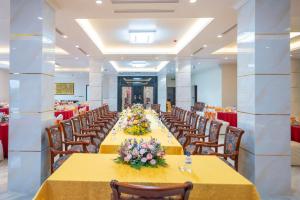 a long banquet hall with yellow tables and chairs at Charmhill Hotel - Tuần Châu in Ha Long