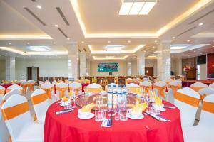 a banquet hall with red and white tables and chairs at Charmhill Hotel - Tuần Châu in Ha Long