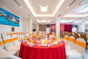 a dining room with a red table and chairs at Charmhill Hotel - Tuần Châu in Ha Long +26 photos