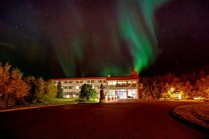 un edificio de oficinas con la aurora en el cielo en Hotel Kjarnalundur- Aurora Dream - Lodges and Rooms, en Akureyri