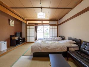 a room with two beds and a couch at Kiso Mikawaya in Kiso