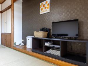 a living room with a flat screen tv on a entertainment center at Kiso Mikawaya in Kiso