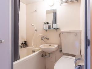 a white bathroom with a sink and a toilet at Kiso Mikawaya in Kiso