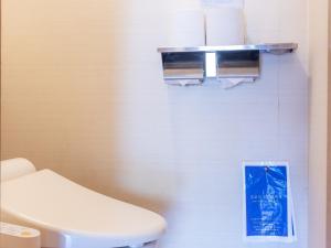 a bathroom with a toilet and a sign on the wall at Kiso Mikawaya in Kiso