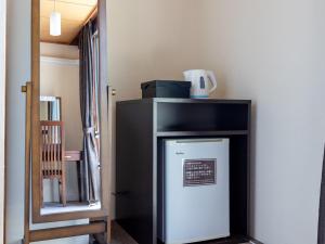 a small refrigerator in a room with a shelf at Kiso Mikawaya in Kiso