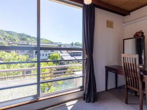 a room with a desk and a window with a view at Kiso Mikawaya in Kiso