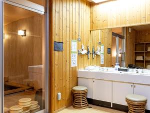 a bathroom with wooden walls and a sink and two stools at Kiso Mikawaya in Kiso