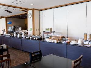 a restaurant with a long counter with a table at Kiso Mikawaya in Kiso