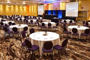 a conference room with white tables and purple chairs at Deerfoot Inn and Casino in Calgary