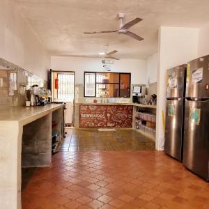 a kitchen with stainless steel refrigerators and a counter at Casa Pura Vida Surf Hostel - Tamarindo Costa Rica in Tamarindo