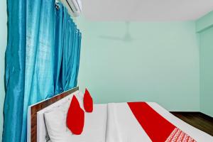a bedroom with a bed with red and white pillows at Flagship Hotel Pritesh Avenue in Nagpur
