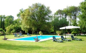 - une piscine avec des chaises et un parasol dans l'établissement La Casa Degli Elfi, à Manziana