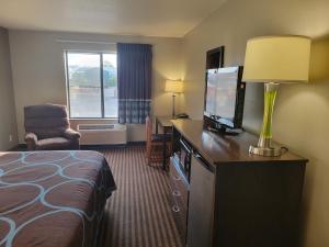 a hotel room with a bed and a television at Super 8 by Wyndham Portage in Portage