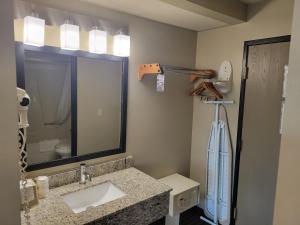 a bathroom with a sink and a large mirror at Super 8 by Wyndham Portage in Portage +17 photos