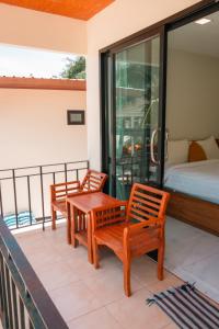 balcone con 2 sedie in legno e 1 letto di JP Resort Koh Tao a Ko Tao