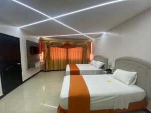 马查拉BRITNEY HOTEL Machala的有两张床和一扇窗户的酒店房间