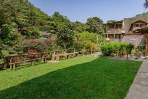 a garden with benches and flowers in front of a house at Cardisch in Santa Rosa de Cabal +28 photos