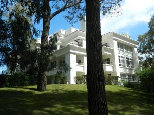 um edifício branco com árvores em frente em Green Park en Uruguay em Punta del Este