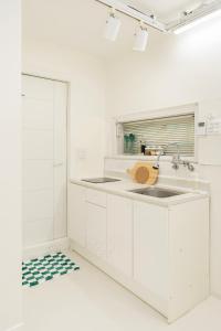 a kitchen with white cabinets and a sink at Emotional, 3type inteior style in Seoul