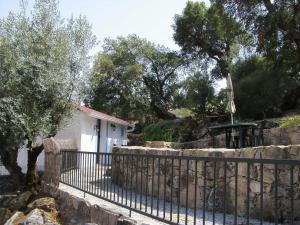 una valla con una pequeña casa detrás de una pared de piedra en Flor da Ramila, en Marvão