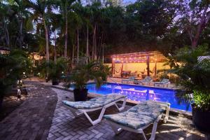 una piscina con 2 sillas, una mesa y una piscina en Casa Corona Del Mar Tamarindo, en Tamarindo