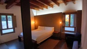 パテルナにあるLoft en molino rehabilitadoのベッドと2つの窓がある寝室 +17枚の写真