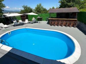 a large blue swimming pool in a yard at Villa maskara in Bihać